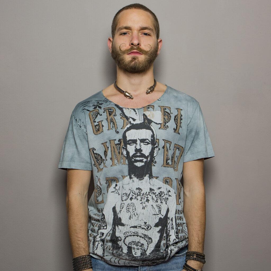 T-shirt with artistic print depicting a man with rabbit ears on his head. The background of the graphic is decorated with stylised letters in a vintage design.